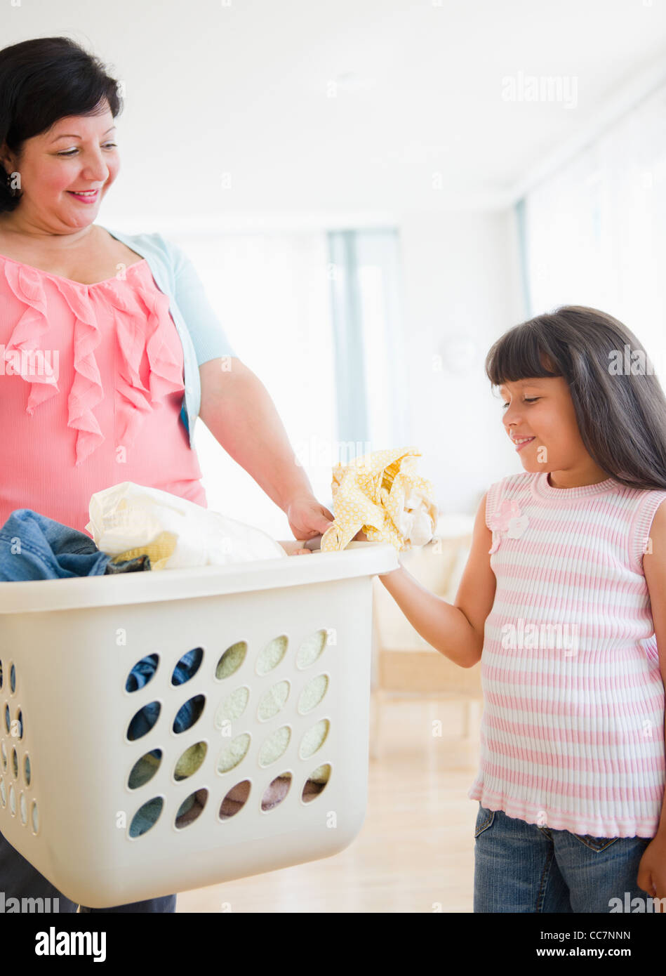 Hispanic mother and daughter doing laundry Stock Photo