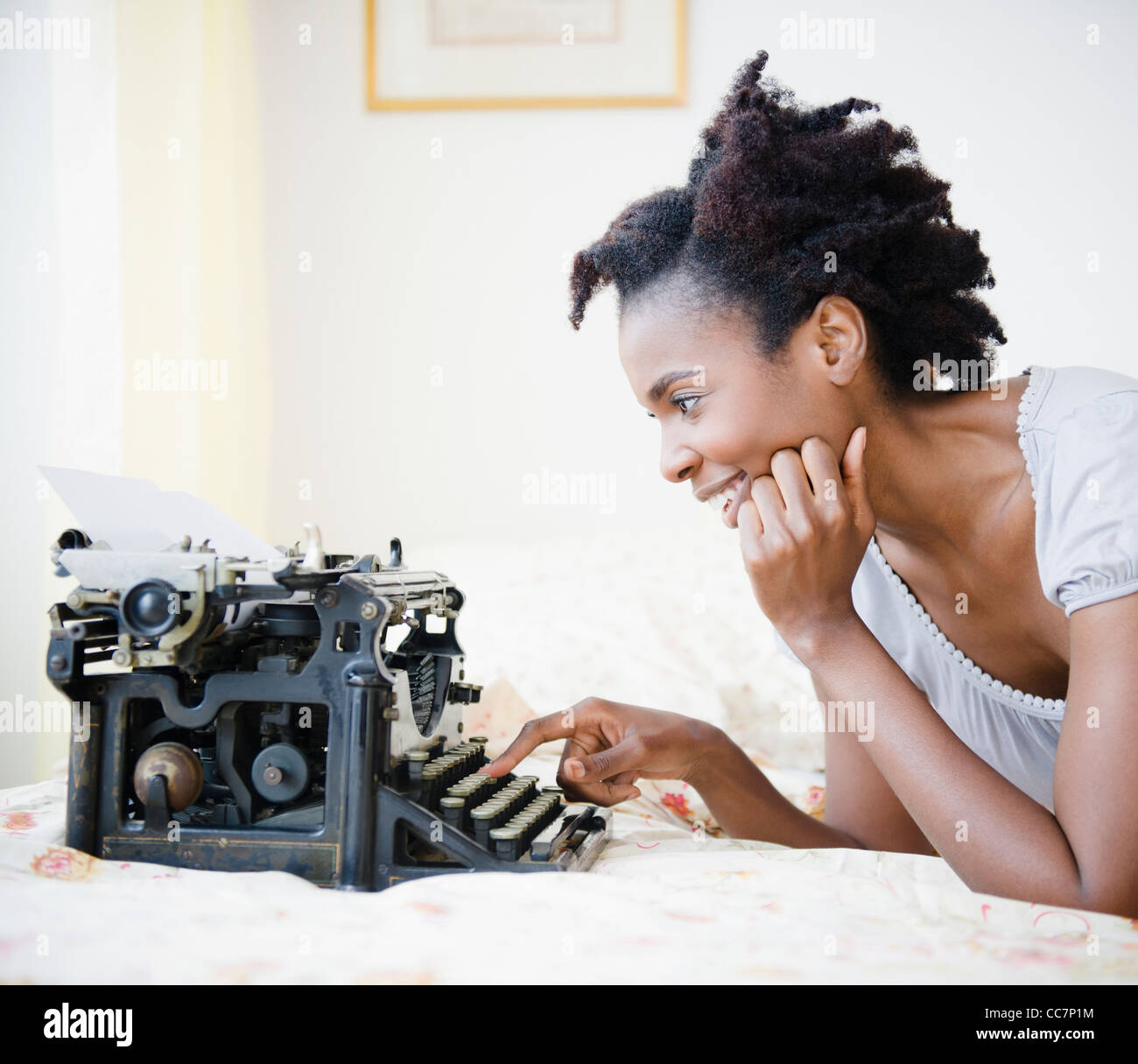 Black woman using old-fashioned typewriter Stock Photo