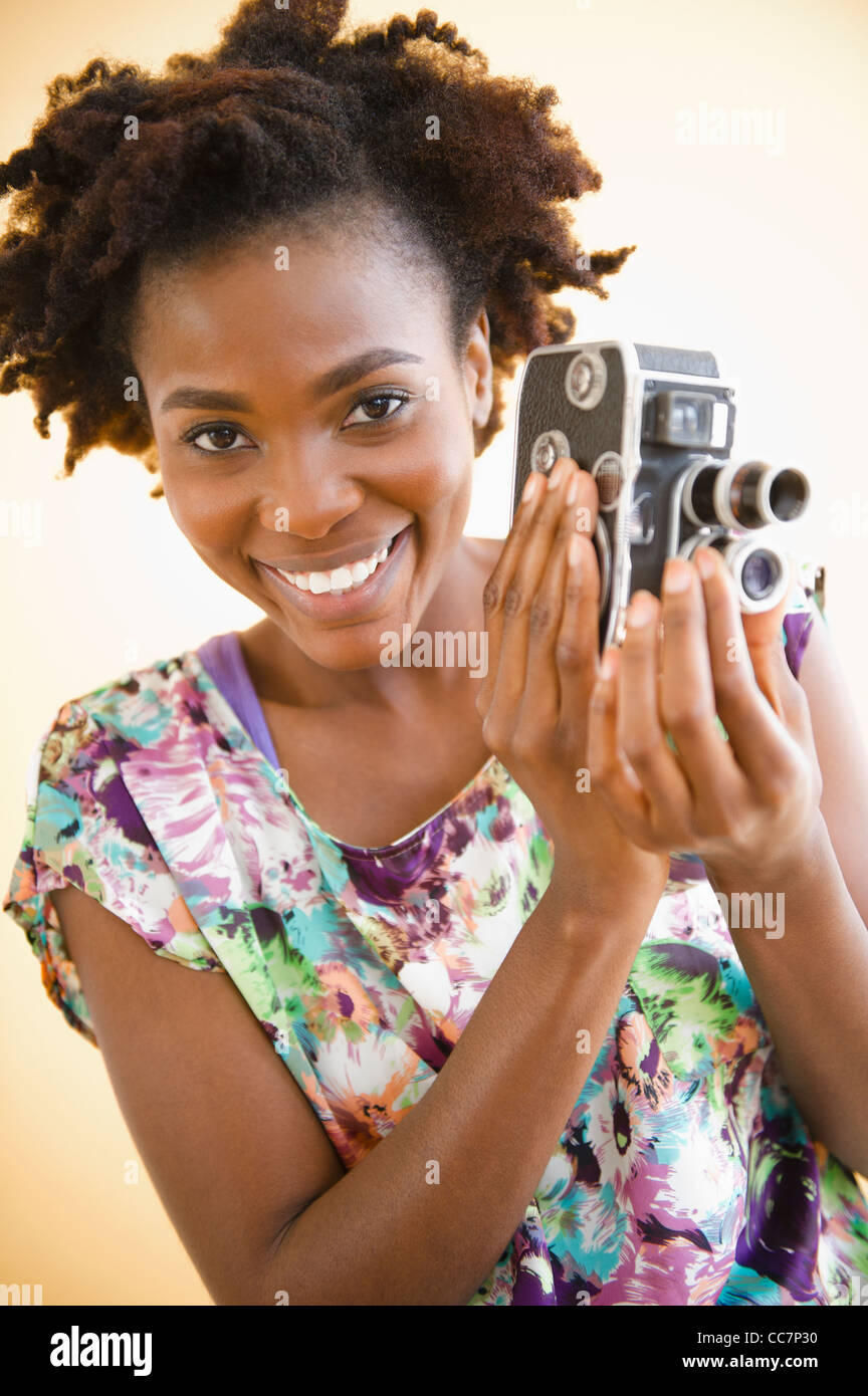 Black woman holding old-fashioned video camera Stock Photo