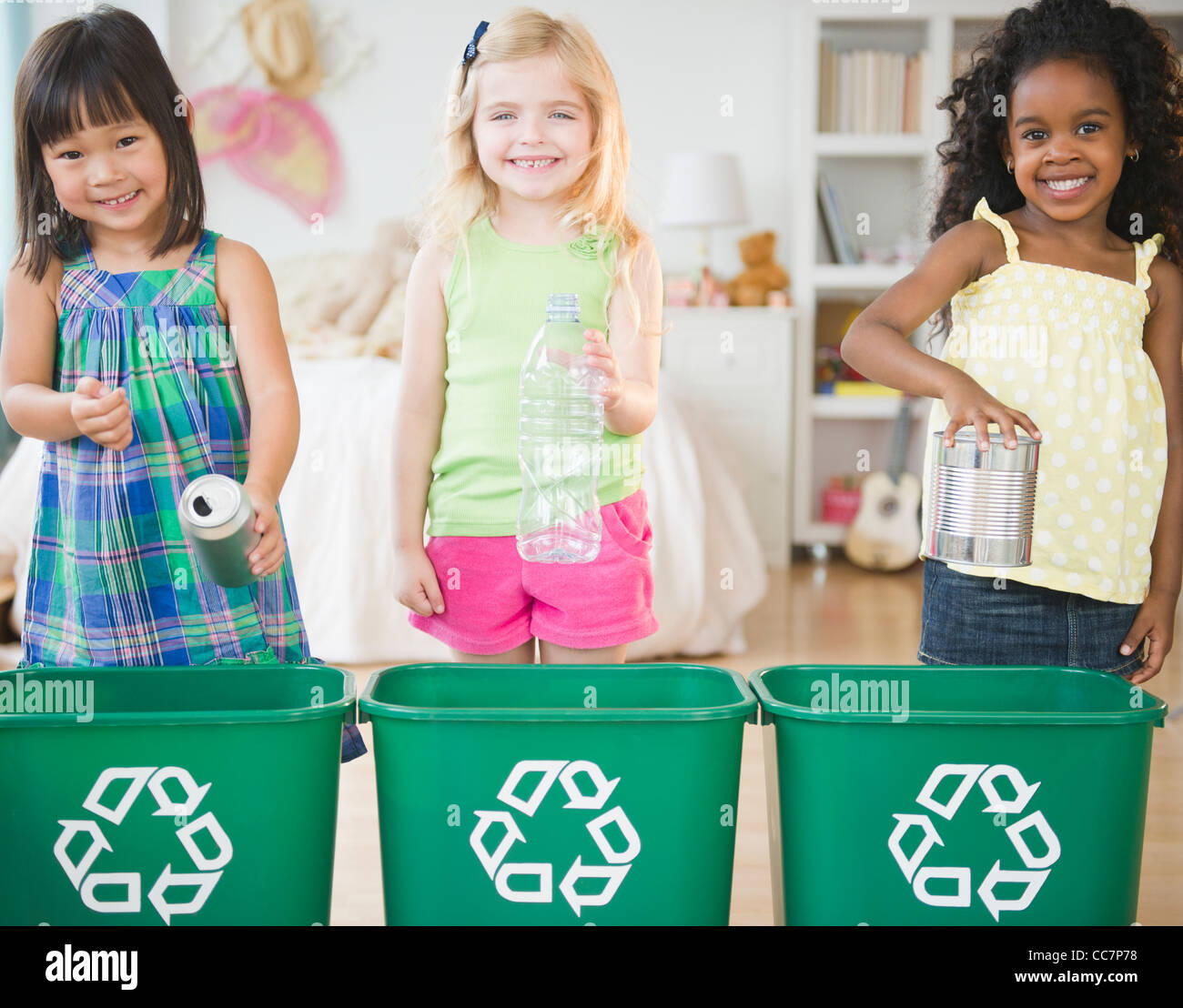 Children putting recyclable materials into recycling bins Stock Photo