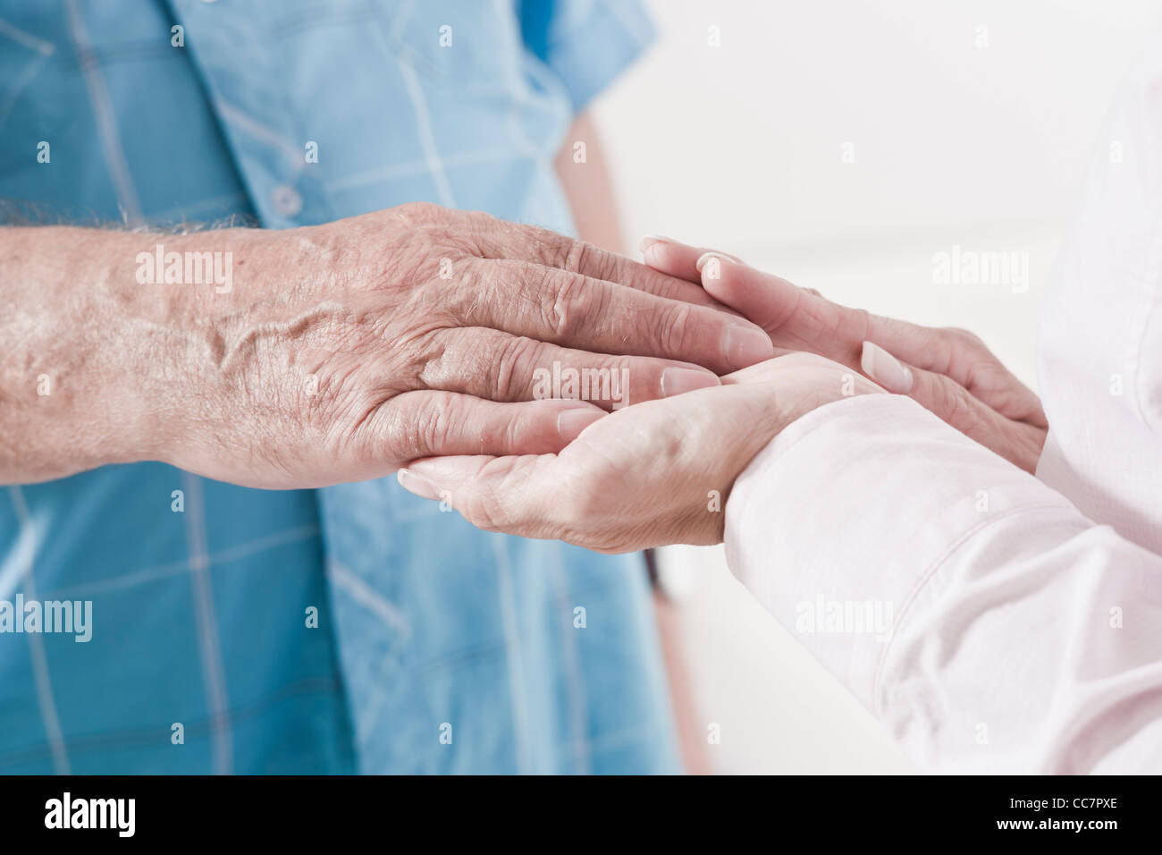 Close-up of Caregiver holding Patient's Hand Stock Photo