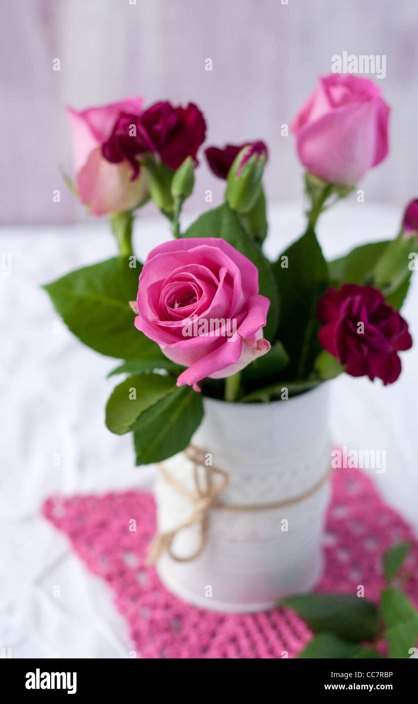 Roses in a white tin can with twine jute Stock Photo