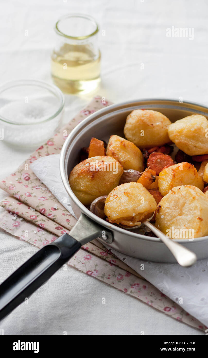 Roast potatoes with garlic and carrots in a pan Stock Photo