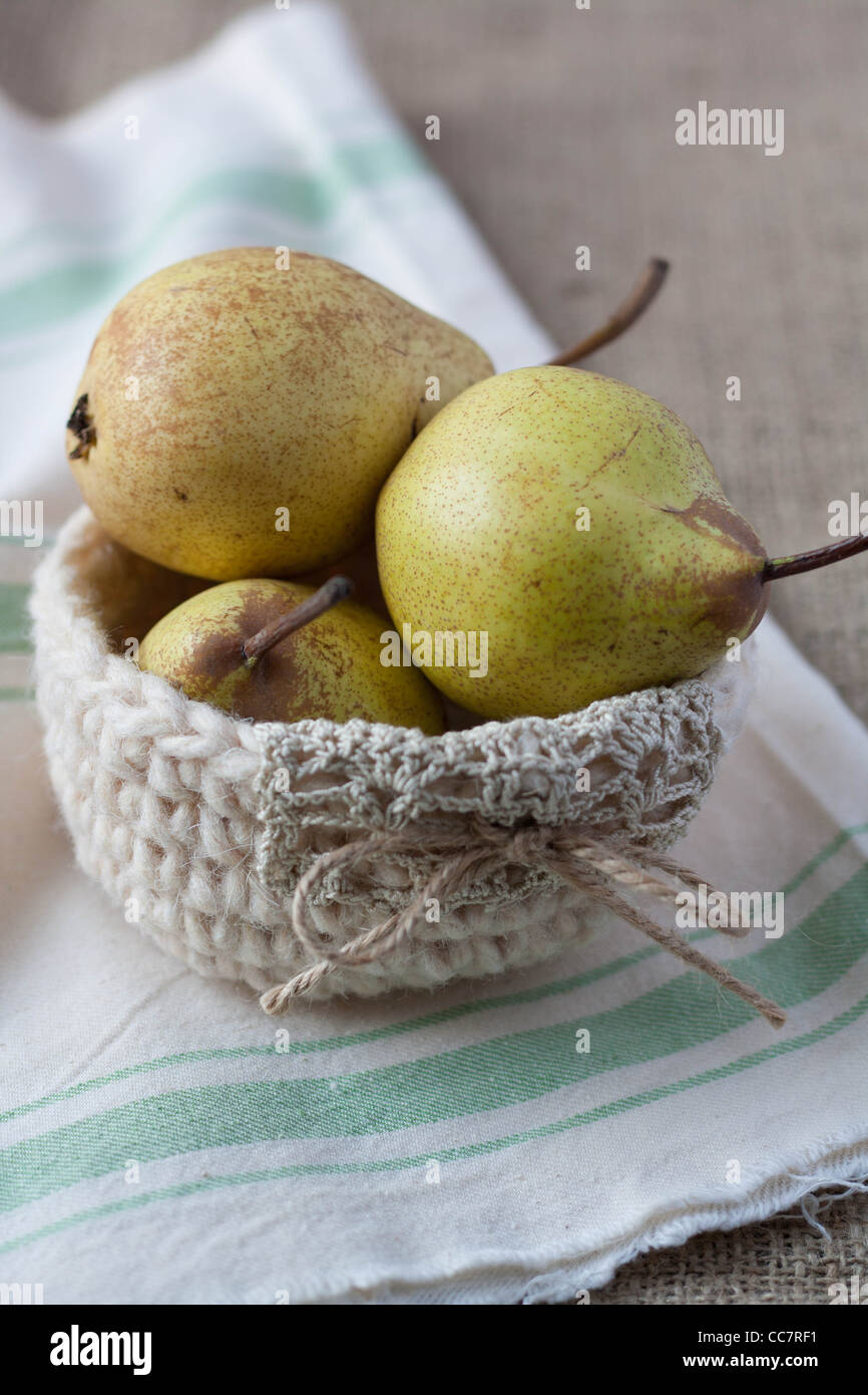 Closeup of pears in a crochet basket on hessian Stock Photo