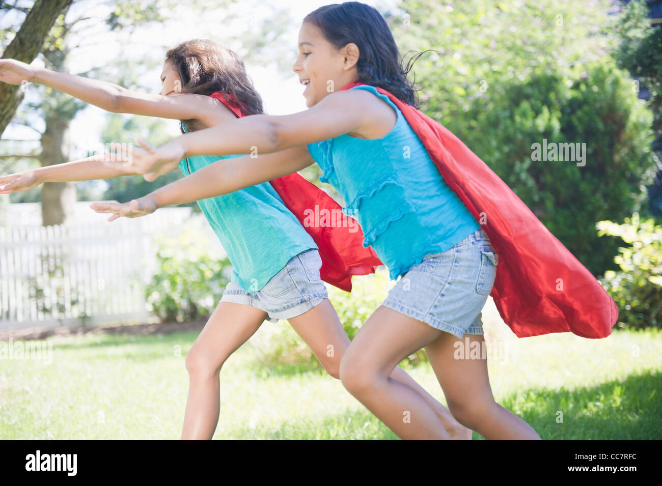 Hispanic girls in capes playing superheroes Stock Photo