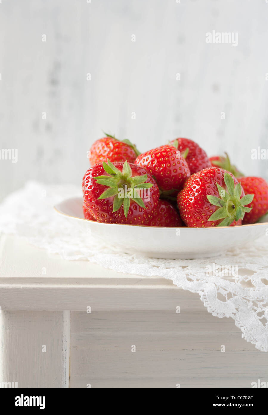 Strawberries on a white table with a crochet mat Stock Photo