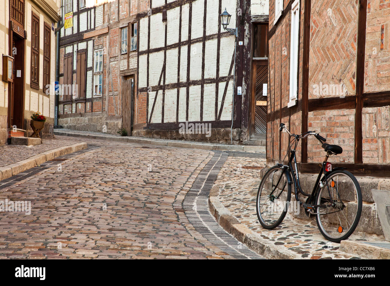 Bicycle in a cobbled street of half-timbered medieval houses in the UNESCO World Heritage town of Quedlinburg, Germany. Stock Photo