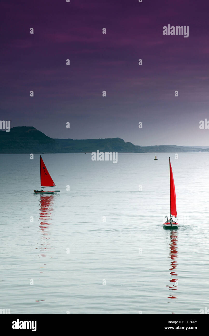 Two 'Topper' sailing dinghies in the English Channel off Lyme Regis