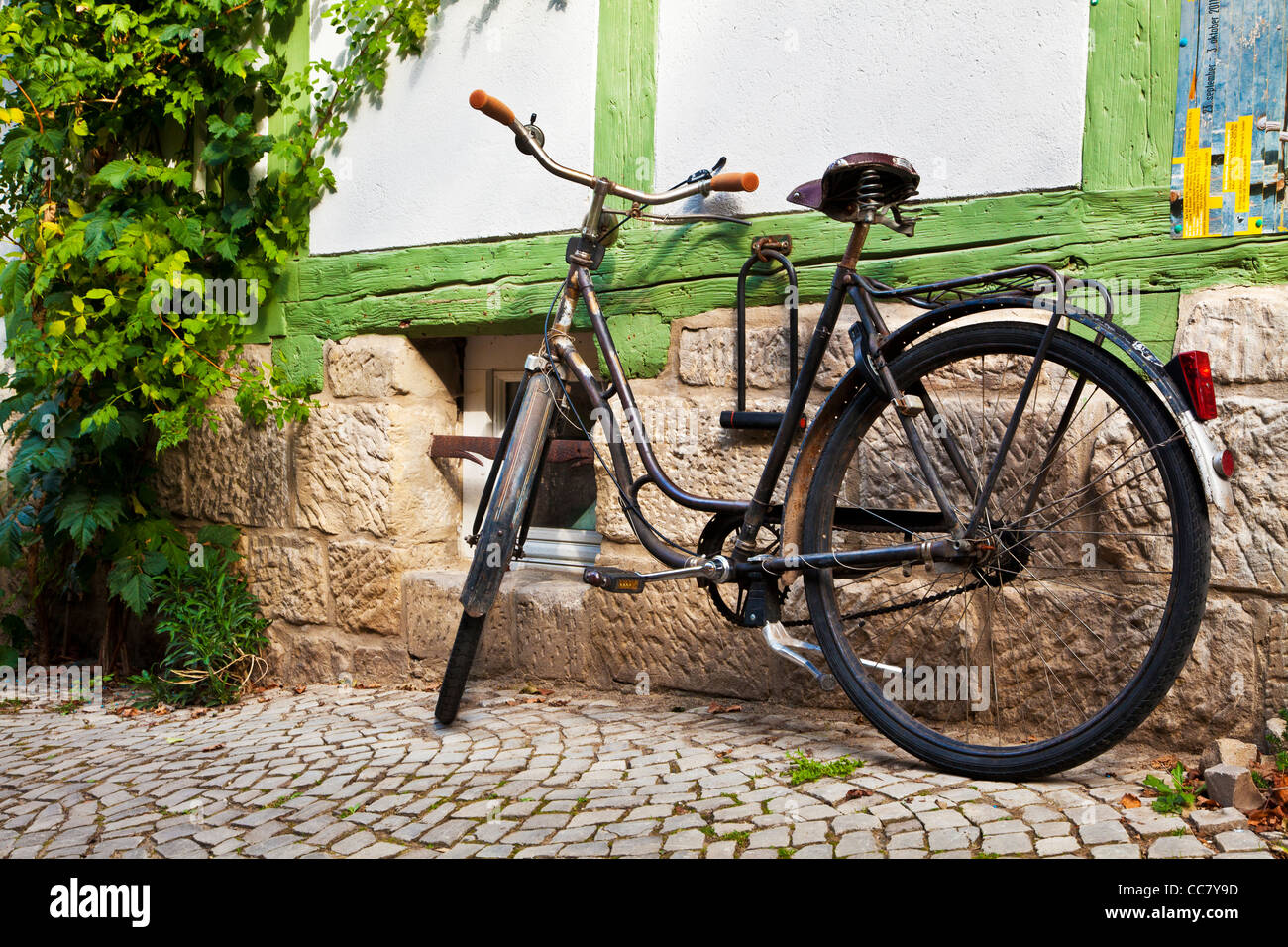 Rusty old bike in a cobbled street of half-timbered medieval houses in the UNESCO World Heritage town of Quedlinburg, Germany. Stock Photo