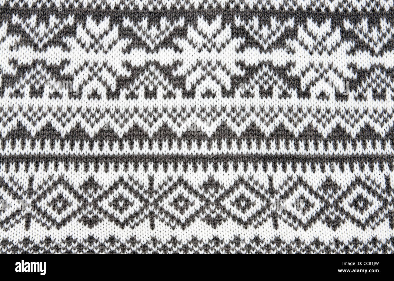 gray background with a knitted pattern to form snowflakes Stock Photo