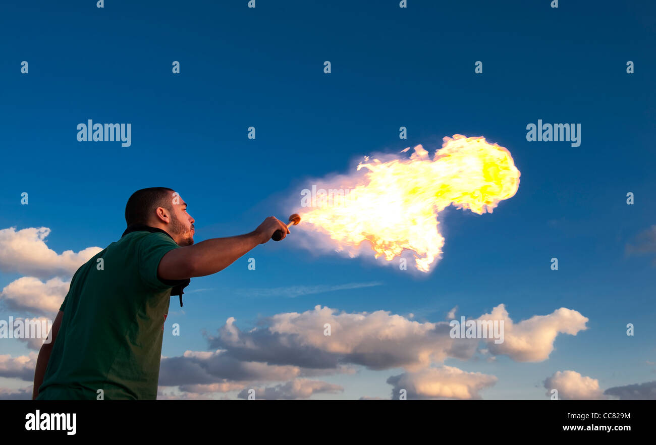 Male fire eater performing at dusk. Stock Photo