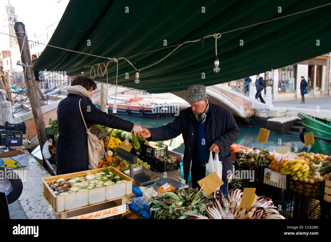 Buying vegeatables anf fresh fruit from a shop on a canal barge Stock Photo