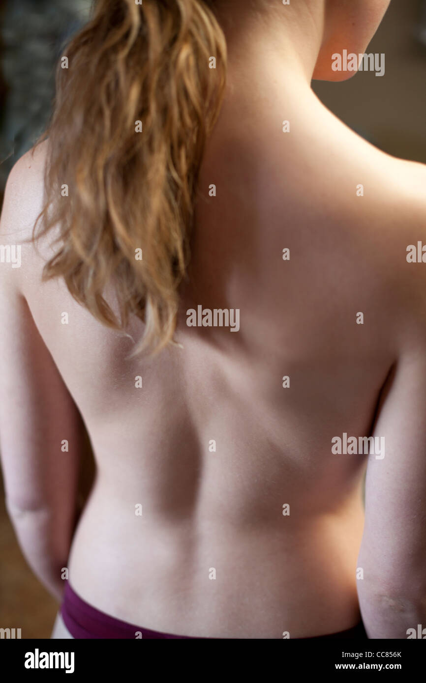 Young woman standing with close up of her nude back. Stock Photo