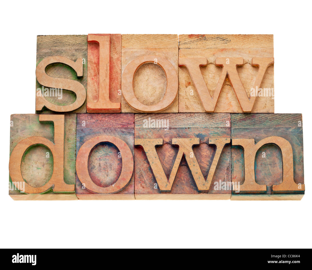 slow down - lifestyle concept - isolated text in vintage wood letterpress printing blocks, stained by color inks Stock Photo