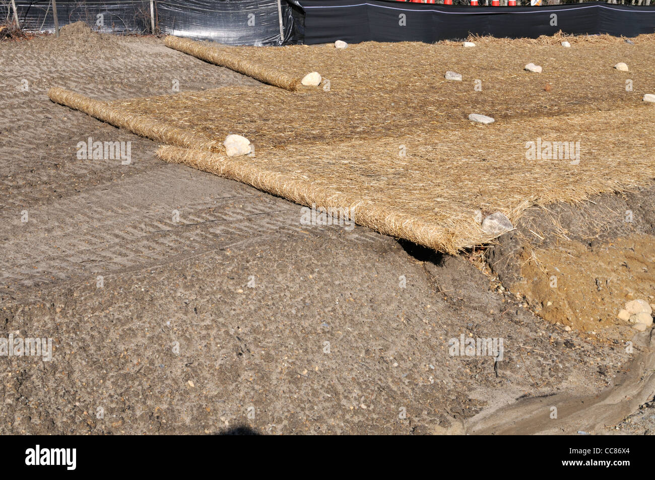 Rolls of biodegradable erosion control blanket on side of new road construction USA Stock Photo