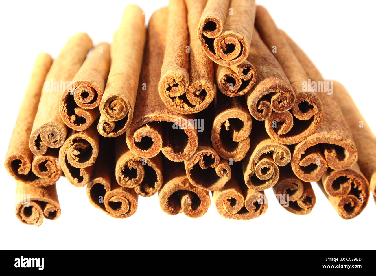 end on view of a pile of cinnamon sticks isolated on white with shallow depth of field Stock Photo
