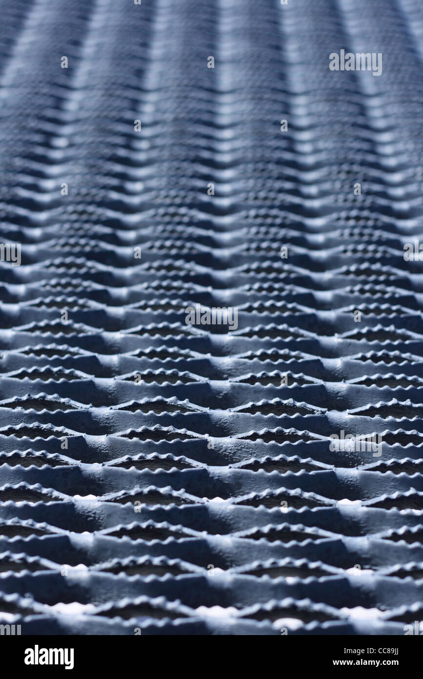angled image of non skid textured corrugated metal tread painted gray with shallow depth of field Stock Photo