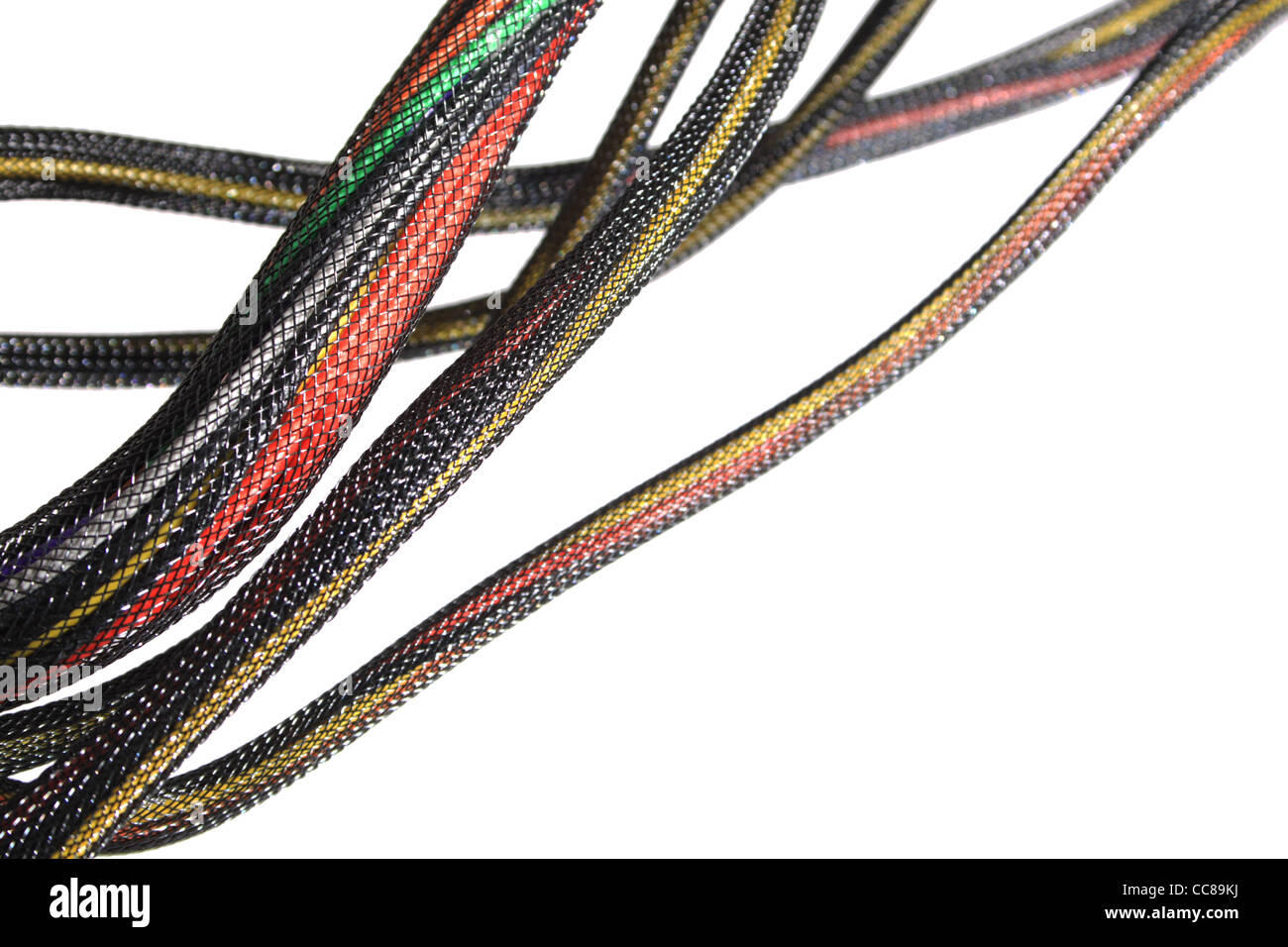 a number of bundled colored wires in black mesh isolated on white with shallow depth of field and copy space Stock Photo