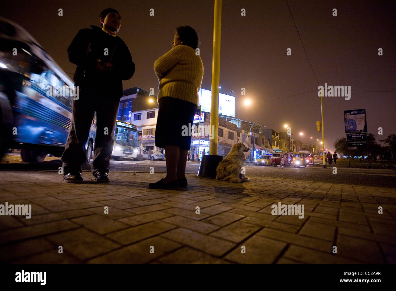 People chat on a busy street corner in Villa el Salvador, in Lima, Peru, South America. Stock Photo