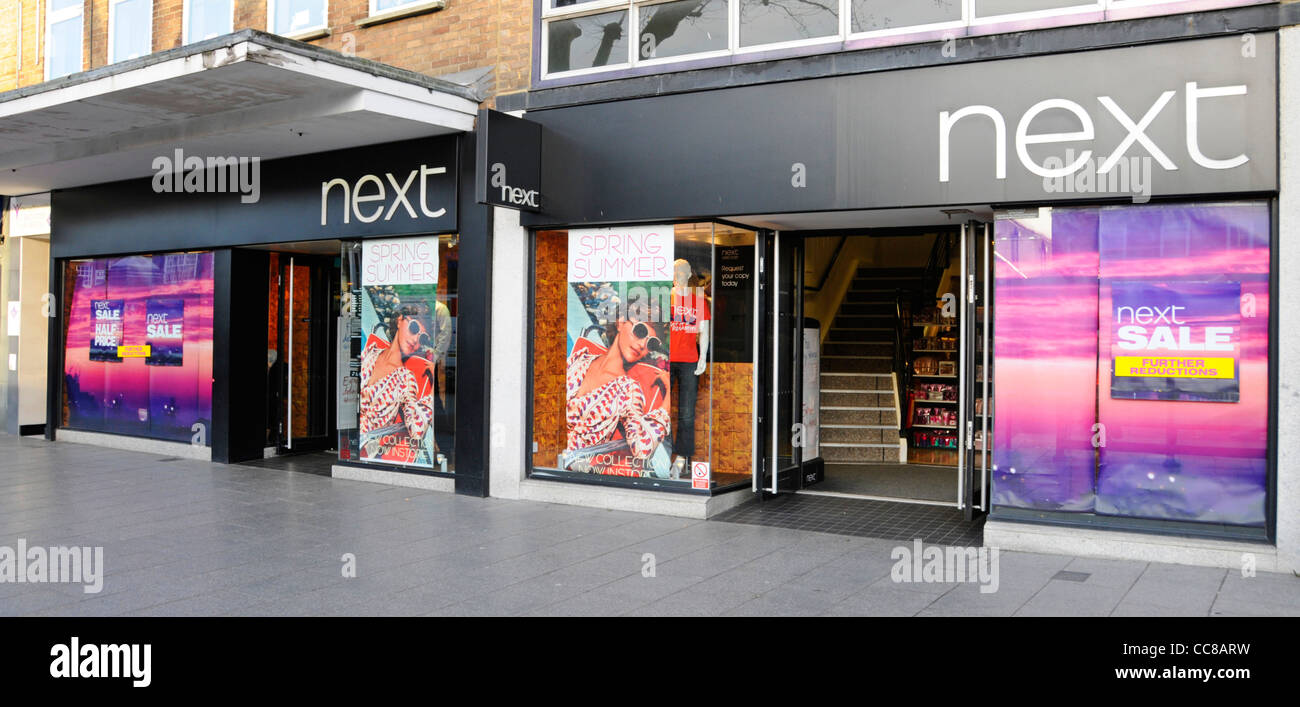 Retail business Next sign for clothing high street store and shop front window display in Brentwood High Street Essex England UK Stock Photo