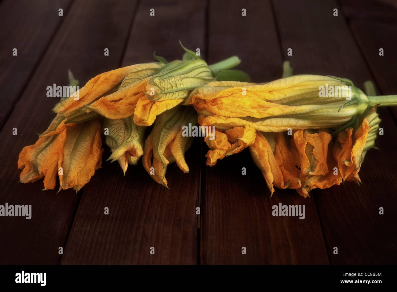 several fresh pumpkin flowers on a wooden table  Stock Photo