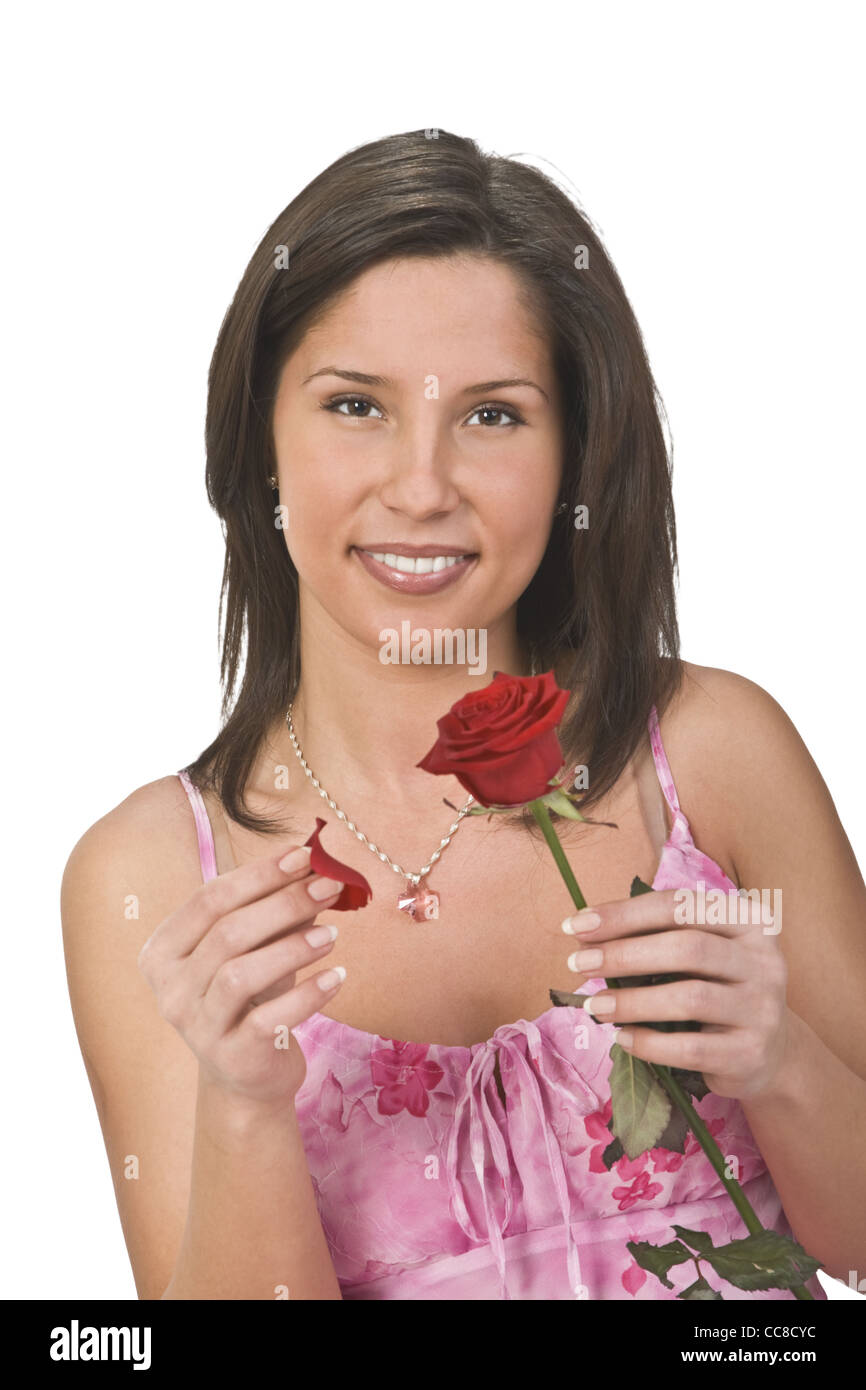 Romantic girl plucking off rose petals while trying to decide on the classical feminine matter