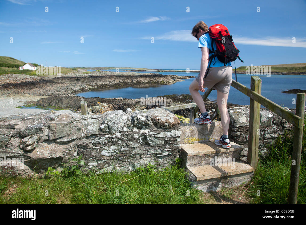 Walker crossing a stile on the Ballyhornan Coastal Path, Lecale Way