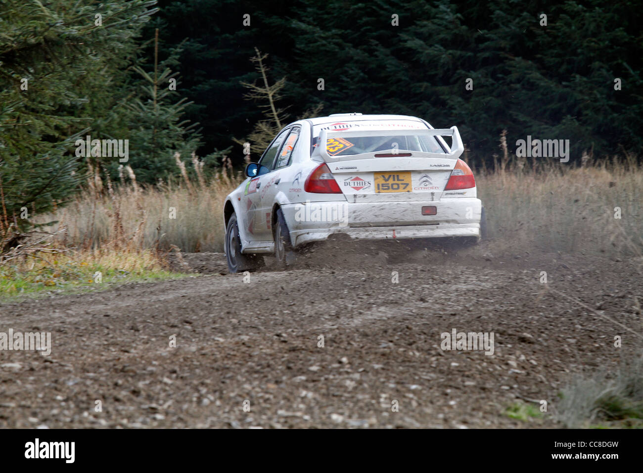 gravel sprays from a rally cars wheels as it passes Stock Photo - Alamy