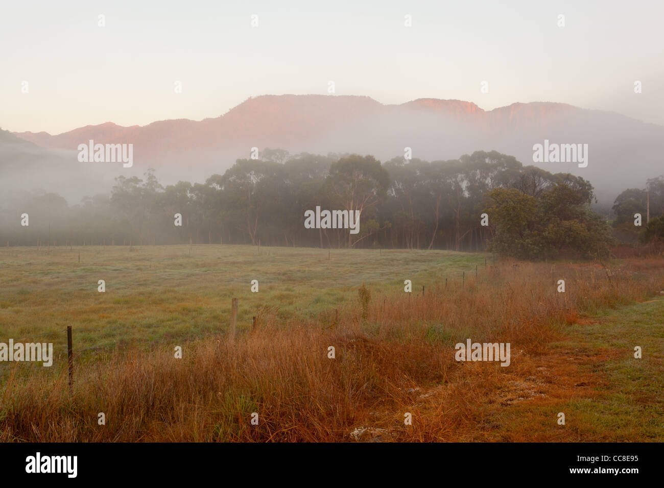 Misty sunrise over Mount Buffalo and Mount Buffalo National Park from Buckland Valley near Porepunkah, Bright in north east Victoria, Australia Stock Photo