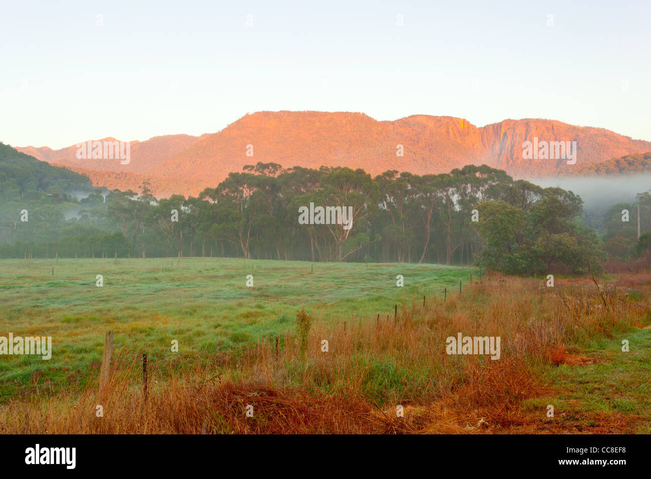 Misty sunrise over Mount Buffalo and Mount Buffalo National Park from Buckland Valley near Porepunkah, Bright in north east Victoria, Australia Stock Photo