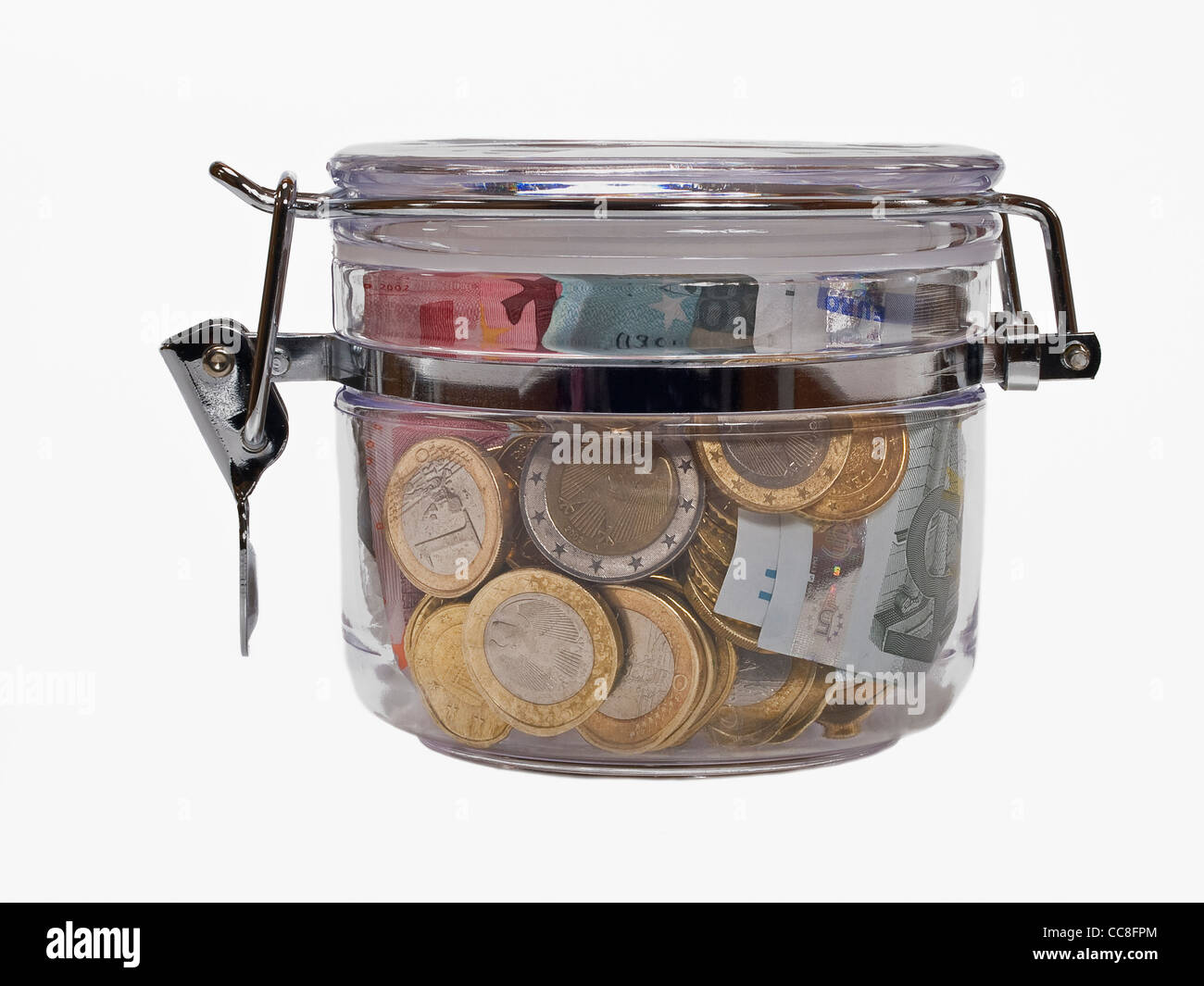 a closed Mason jar, Euro-Coins and Banknotes are inside Stock Photo