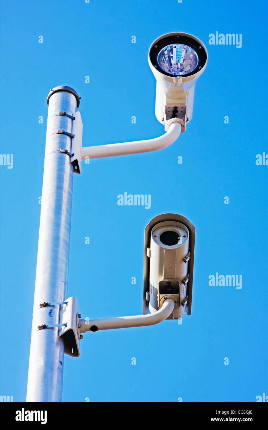 traffic security and speed camera mounted on pole and against clear sky ...