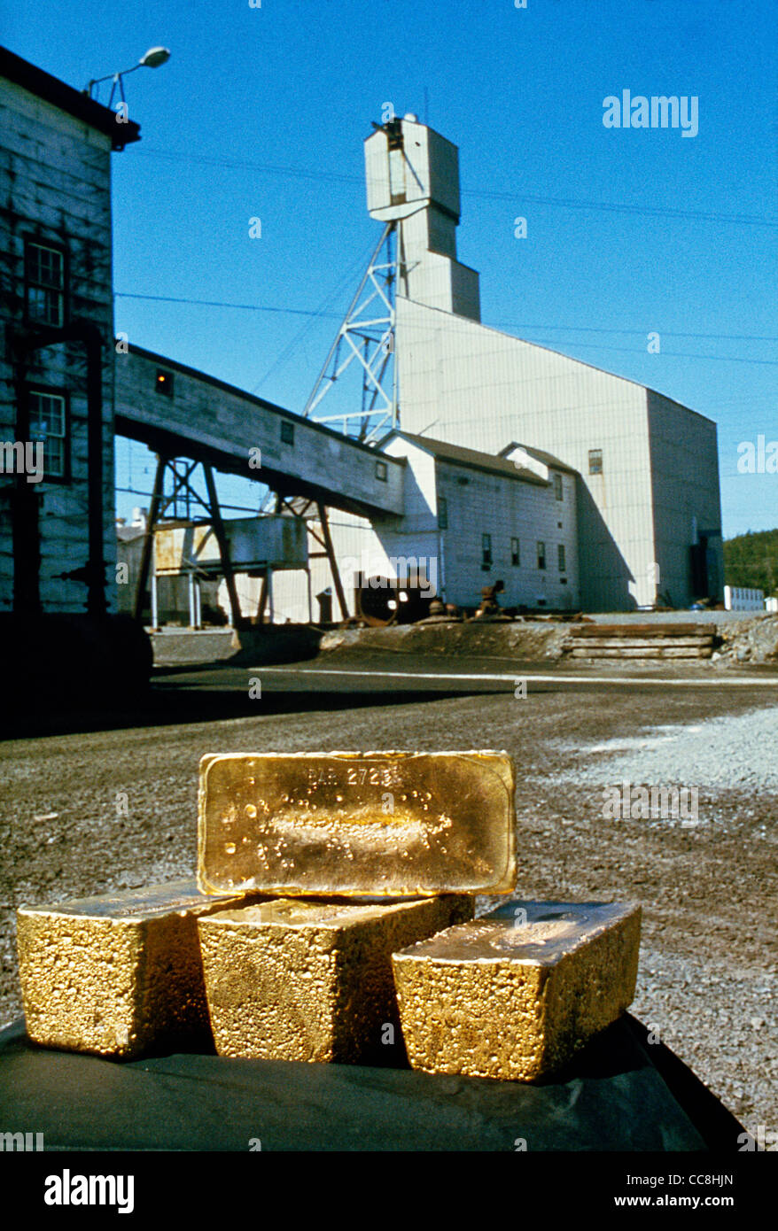 Four - 90lbs.Ingots of gold with mining shaft in background in Red Lake;Northern Ontario;Ontario;Canada Stock Photo