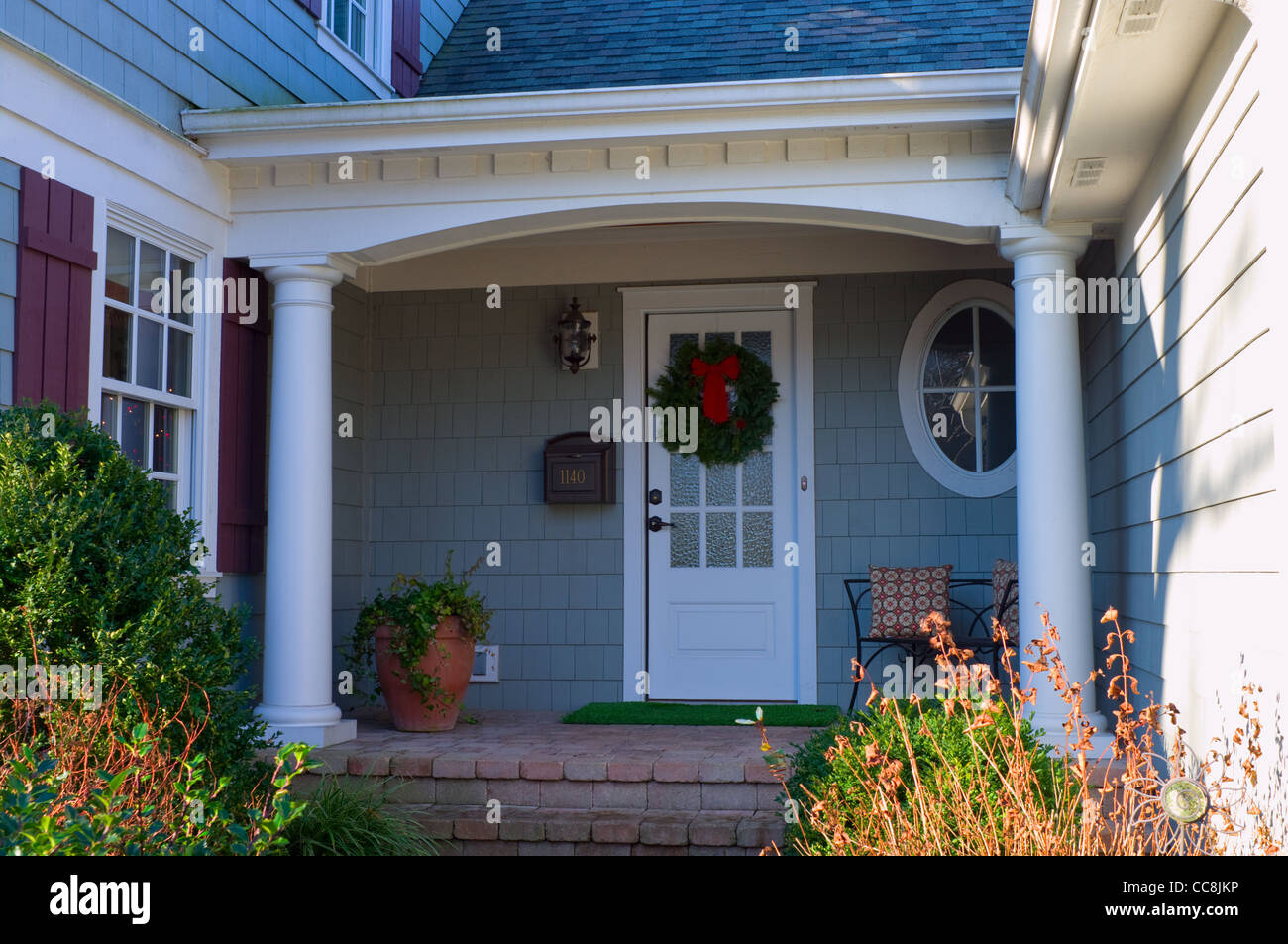 Private residence front porch and entrance adorned with Christmas wreath Stock Photo