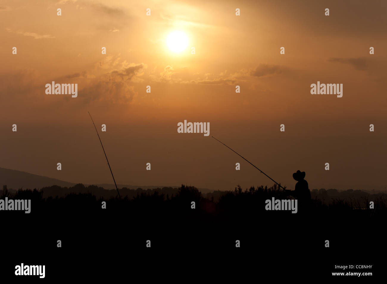 silhouette of a fisherman at sunset Stock Photo - Alamy