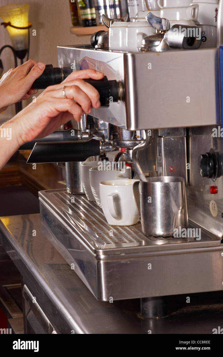 Barman operating an Italian espresso machine inside a bar Stock Photo