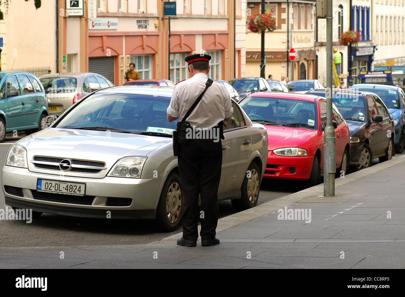 Traffic warden issuing a ticket for a parking offence, Londonderry,Northern Ireland,UK Stock Photo