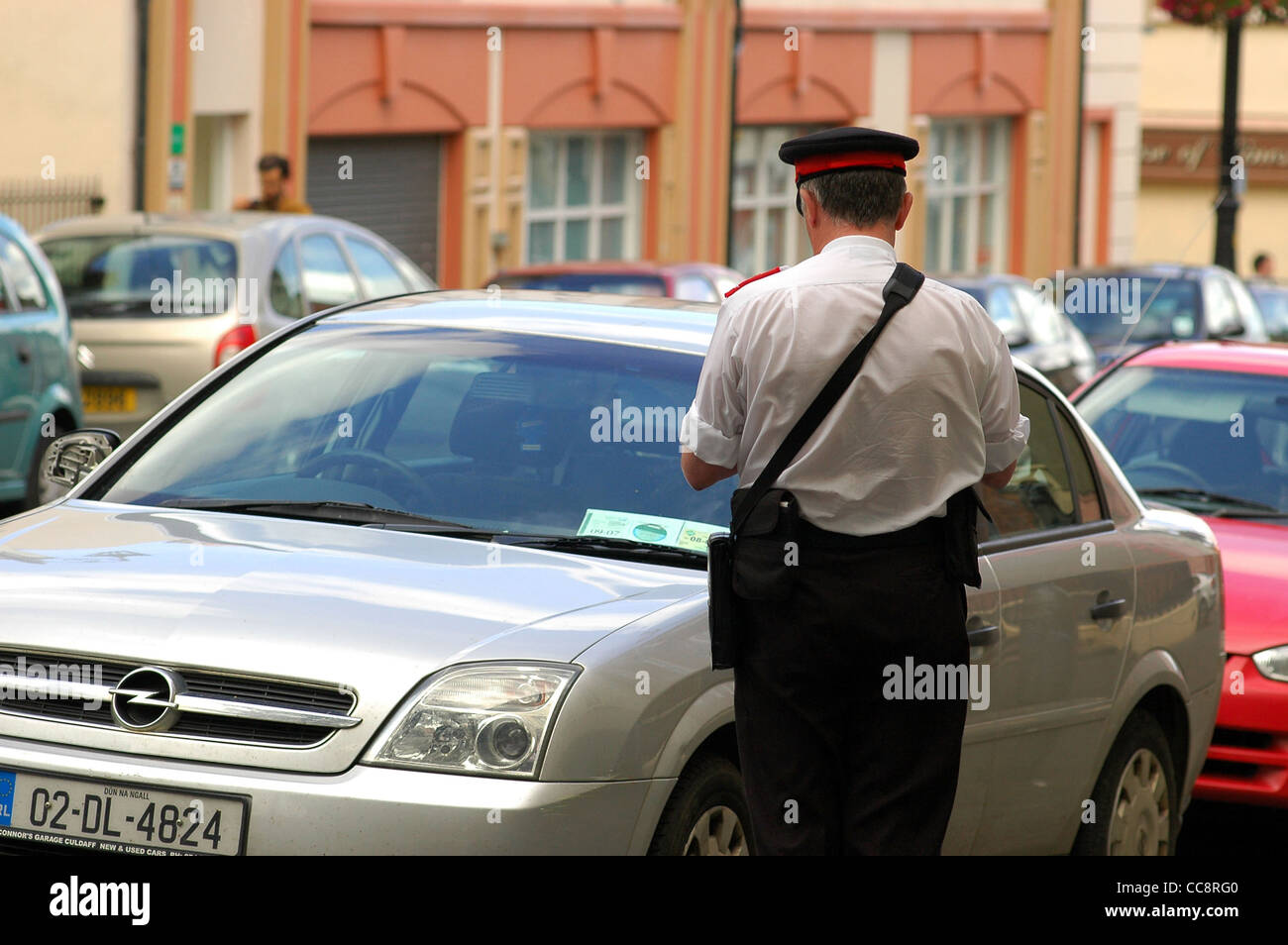 Traffic warden issuing a ticket for a parking offense, Londonderry,Northern Ireland,UK Stock Photo