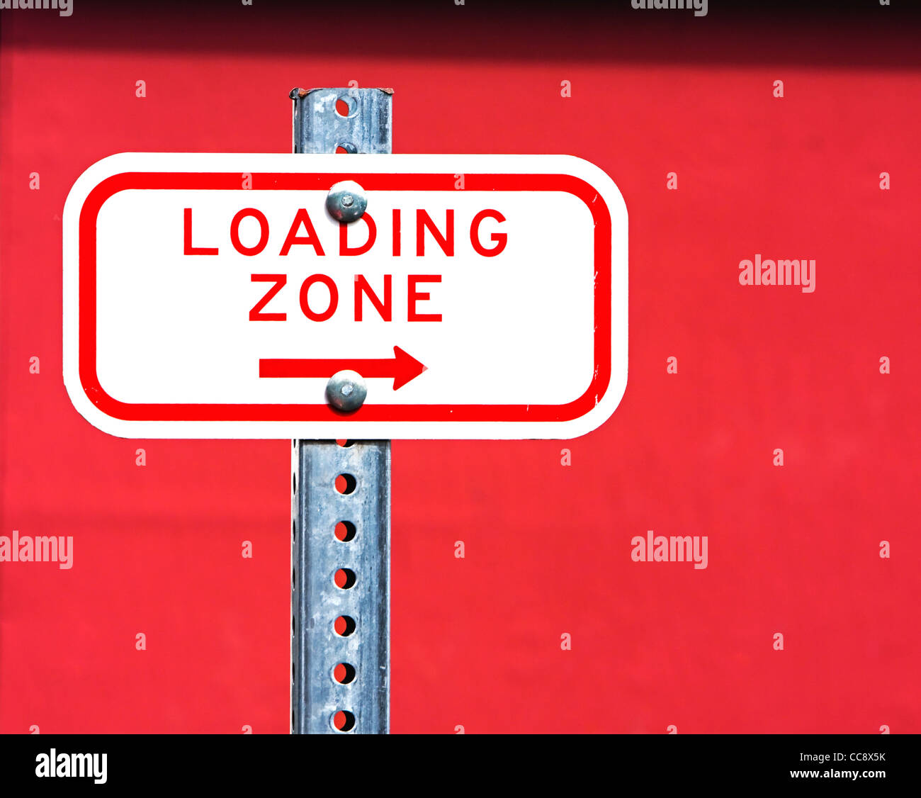 loading zone sign against red wall Stock Photo - Alamy