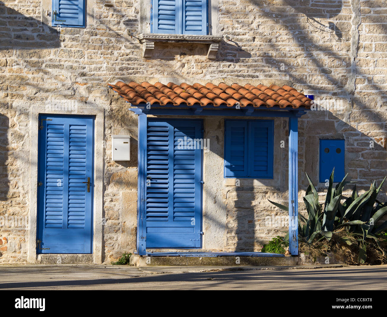 stone house with blue door and windows and agava Stock Photo - Alamy