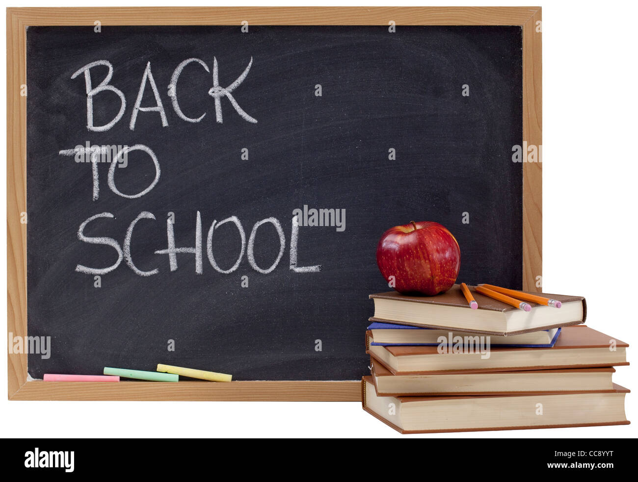 back to school concept - white chalk handwriting on blackboard, stack of old books, red apple and yellow pencils Stock Photo