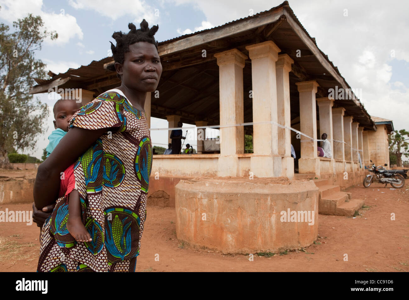 A mother carries her young child to a health centre in Kumi, Uganda, East Africa. Stock Photo