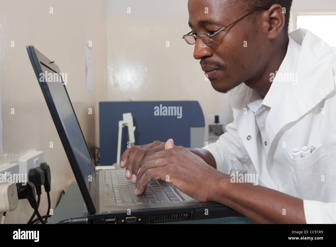 A lab technician works on a laptop computer in a laboratory in Ibenga