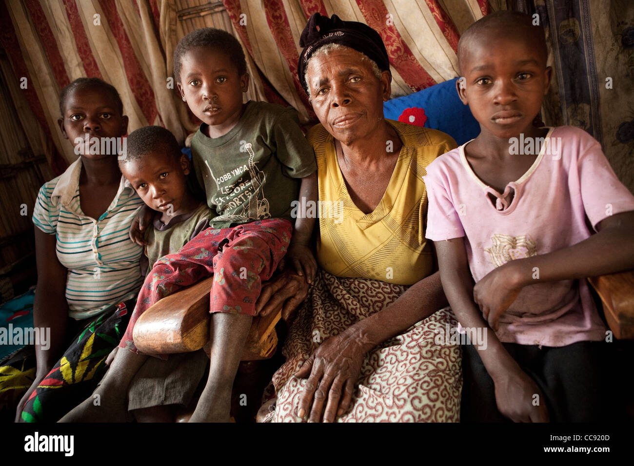 A grandmother and her children sit together in their house in Mongu, Zambia, Southern Africa. Stock Photo