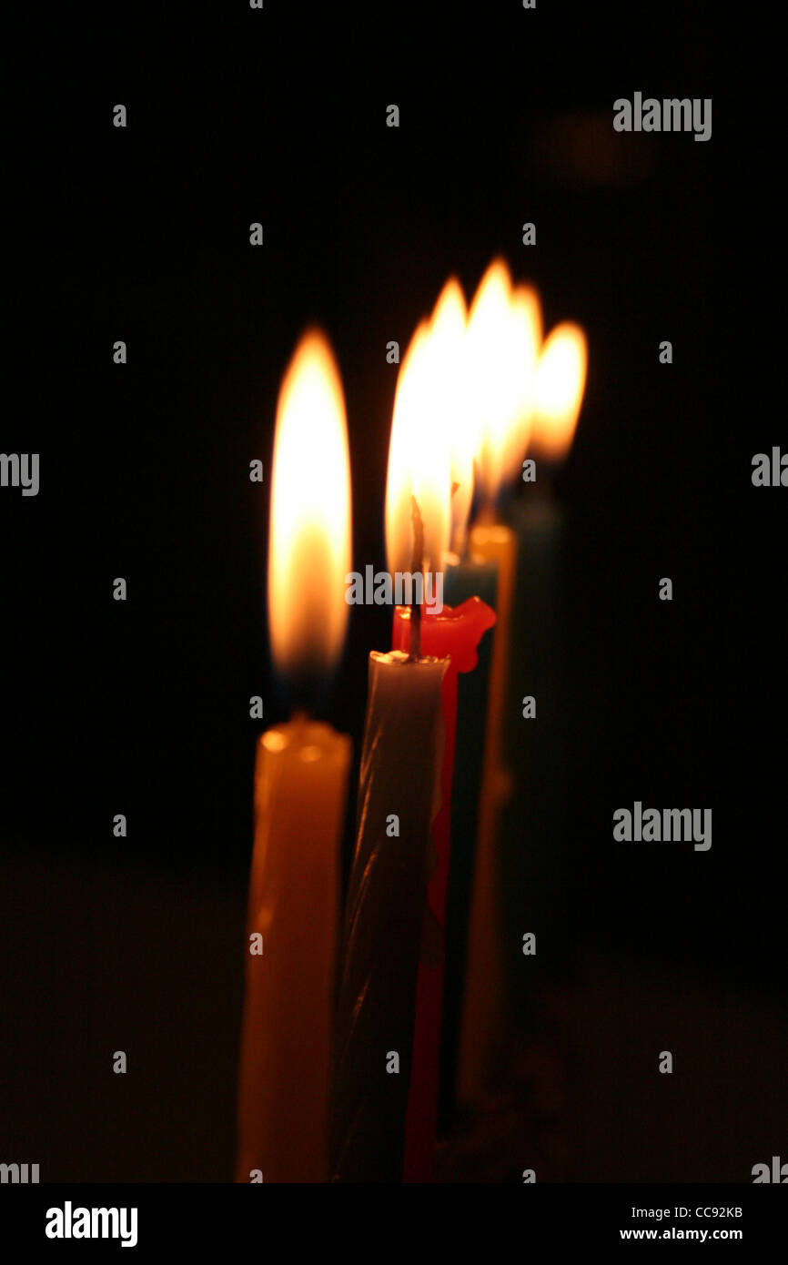 Candles burning against dark background Stock Photo - Alamy
