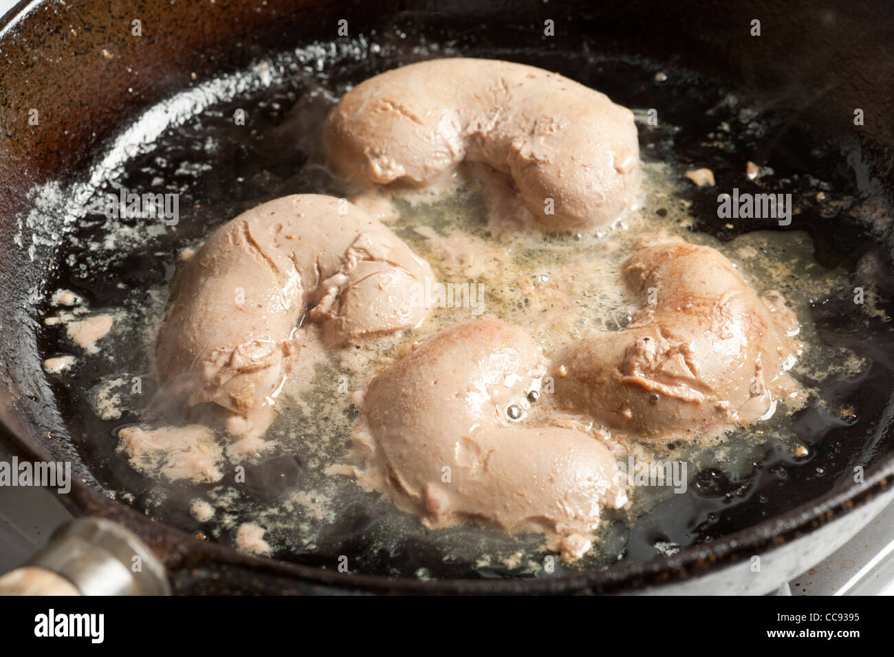 Lamb kidneys frying in a skillet Stock Photo