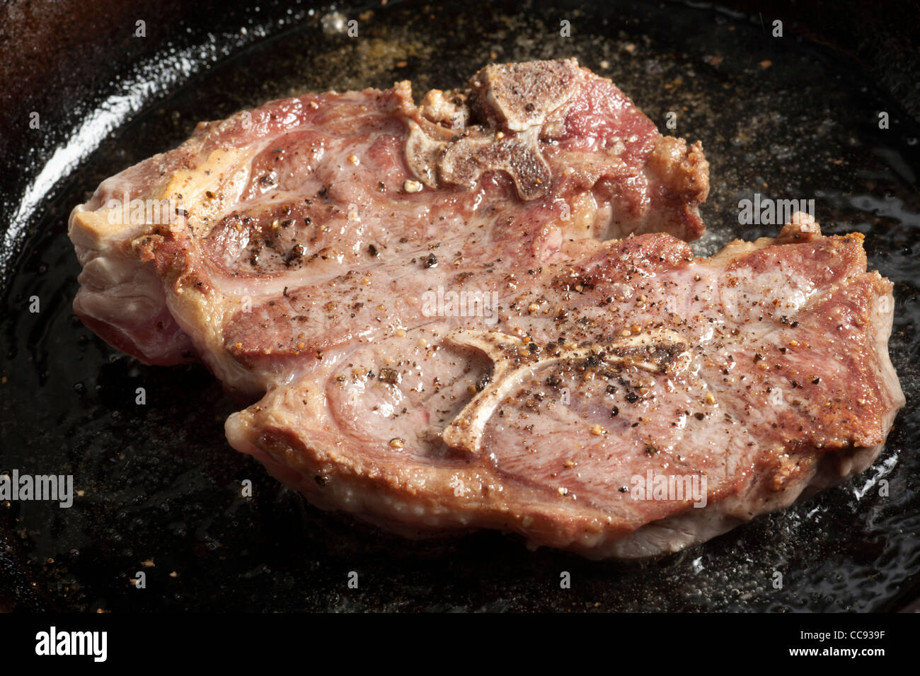 A lamb chop frying in a skillet Stock Photo Alamy
