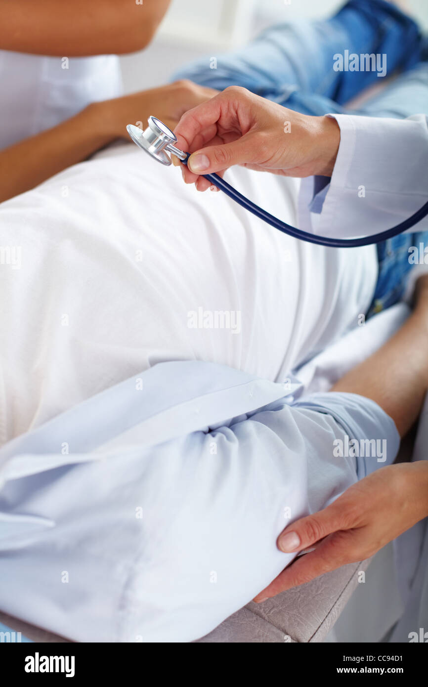 Portrait of two female doctors looking at patient during medical ...