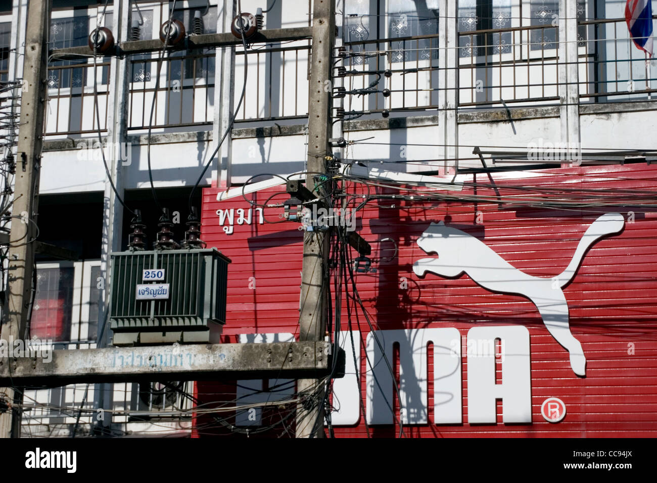 A large Puma sign is on display high above urban housing on a city street  in Chiang Rai, Thailand Stock Photo - Alamy