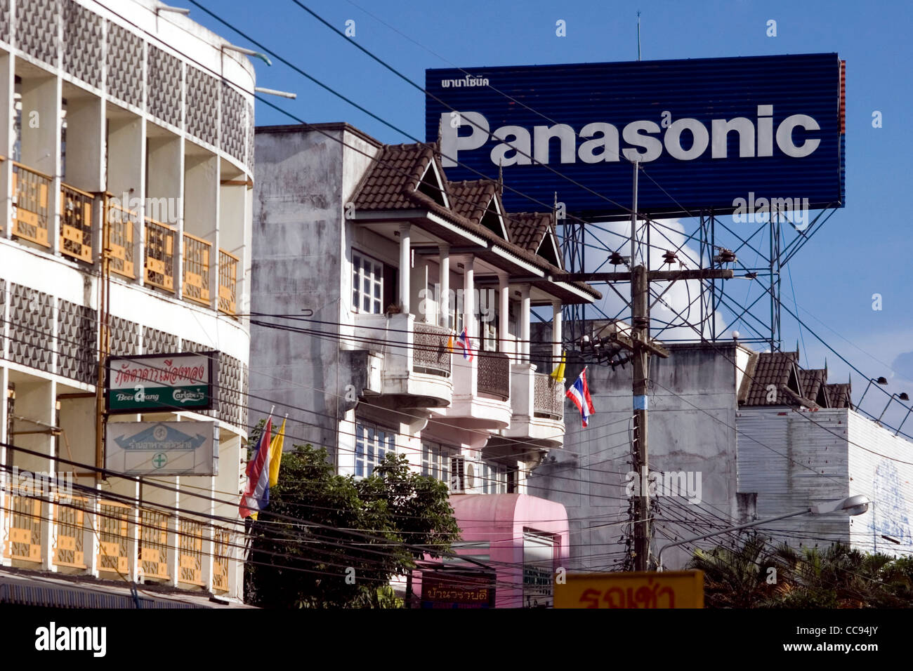 A large Panasonic sign is on display high above urban housing on a city street in Chiang Rai, Thailand. Stock Photo